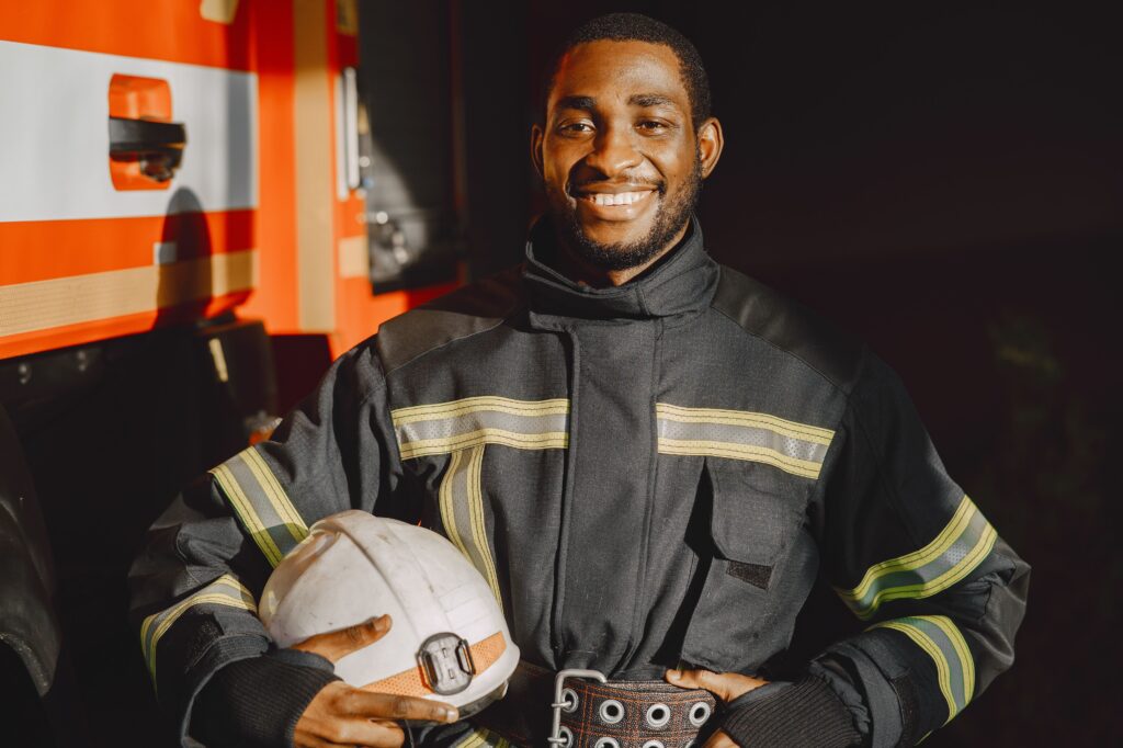 Bombeiro civil usando equipamento de proteção completo e segurando um extintor, transmitindo profissionalismo e prontidão.
